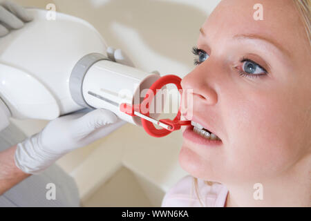 Dentista in sala esame con la donna in sedia Foto Stock