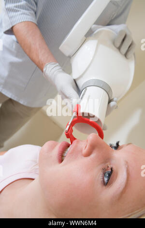 Dentista in sala esame con la donna in sedia Foto Stock