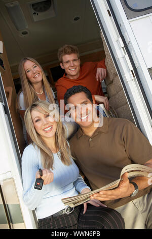 La famiglia felice nella porta di nuovo RV Foto Stock