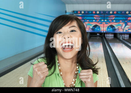 Giovane donna celebrando Bowling cliente Foto Stock