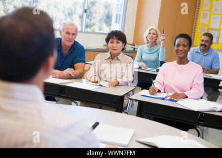 Femmina matura studente alzando la mano in classe Foto Stock