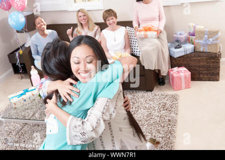 Gli amici sorseggiando un bambino, doccia Foto Stock