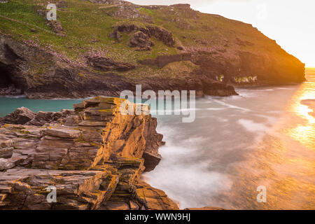 Le rovine del castello di Tintagel su Tintagel isola al tramonto, un sito collegato con la leggenda di Re Artù, Cornwall, England, Regno Unito Foto Stock