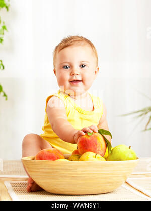 Little baby azienda frutta fresca Foto Stock