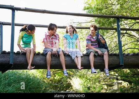 Teens seduta sul ponte Foto Stock