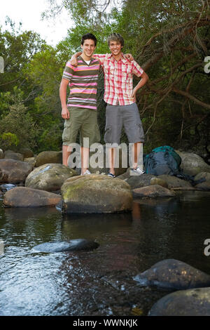 I giovani escursionisti in piedi sulle rocce da Creek Foto Stock