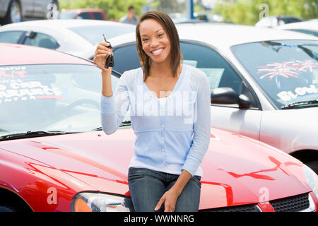 Donna captare nuove auto da lotto Foto Stock