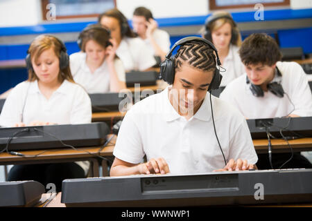 Gli studenti nella classe di musica lavorando sulle tastiere Foto Stock