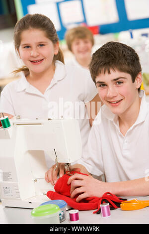 Maschio e femmina studente utilizzando macchina da cucire Foto Stock
