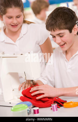 Maschio e femmina studente utilizzando macchina da cucire Foto Stock