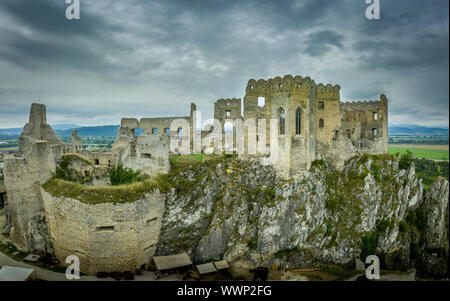 Vista aerea della rovina medievale castello di Beckov in Slovacchia al di sopra del fiume Vah con cappella gotica e cielo tempestoso Foto Stock