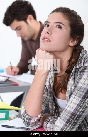 Giovane donna fantasticando in classe Foto Stock