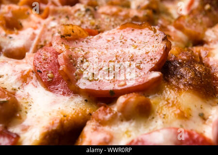 La pizza italiana con pancetta, salame e formaggio mozzarella Foto Stock