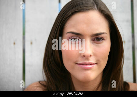 La donna si fermò di fronte recinzione di legno Foto Stock