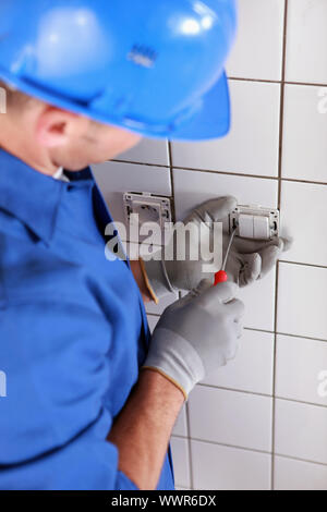 Elettricista cablaggio un interruttore della luce Foto Stock