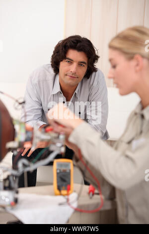 Donna riparazione di computer e di uomo seduto su un divano Foto Stock