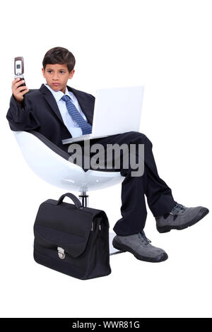 Ragazzo giovane vestito come un burbero uomo d affari Foto Stock