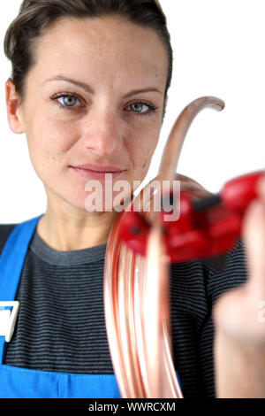 Donna di taglio della tubazione in rame Foto Stock