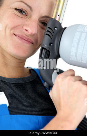 Closeup Ritratto di giovane donna bionda apprendista azienda puntatrice Foto Stock