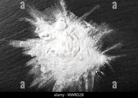 Bianco in polvere farmaco sparsi su una tavola nera. luogo per il testo Foto Stock