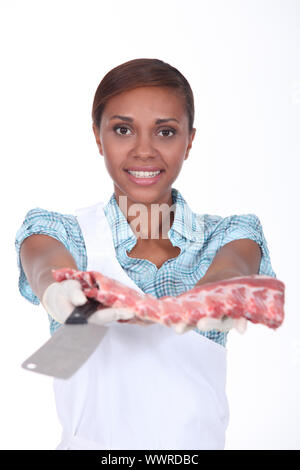 Macelleria femmina con un rack di nervature Foto Stock