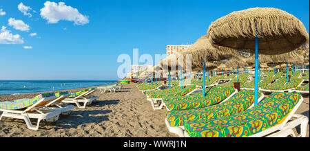 Vista panoramica di sedie a sdraio e ombrelloni di paglia su una spiaggia. Torremolinos Costa del Sol, Andalusia, Spagna Foto Stock