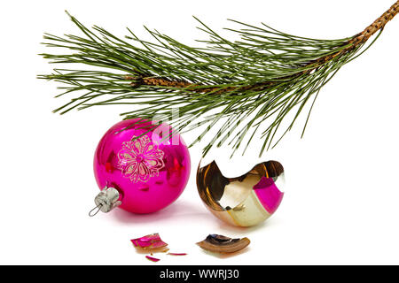 Rotture di palla di Natale si trova al disotto del ramo del pino, isolato su sfondo bianco Foto Stock