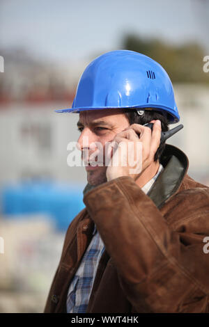 Operaio edile parla nel suo walkie-talkie Foto Stock