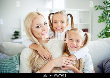 Close-up verticale di tre belle carino adorabile amabile attraente winsome allegro persone positive pre-teen ragazze cuddling delicato mamma mamma mamma in Foto Stock