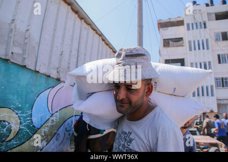 La striscia di Gaza, la Palestina. Xvi Sep, 2019. I rifugiati palestinesi ricevere forniture alimentari a un'UNRWA centro di distribuzione di al- Shati Refugee Camp nel nord della Striscia di Gaza. Secondo le Nazioni Unite, più di un milione di palestinesi nella striscia di Gaza attualmente vivono in povertà e si basano sulla UNRWA di assistenza. Credito: ZUMA Press, Inc./Alamy Live News Foto Stock