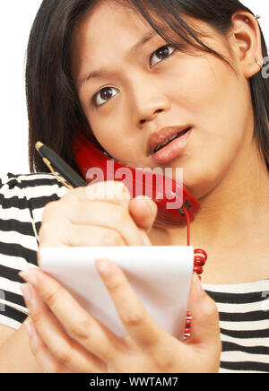 Donna che parla al telefono per prendere appunti e guardando sorpreso Foto Stock