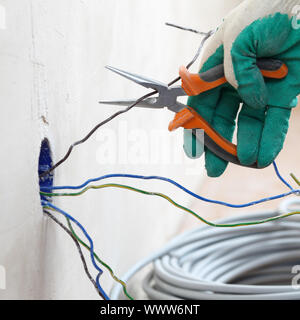 Lavoratore mette i fili nella parete Foto Stock