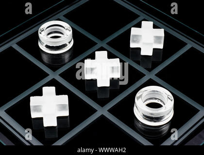 Vetro tic-tac-toe gioco su sfondo nero Foto Stock