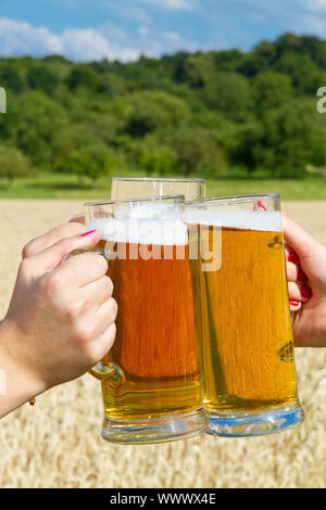 Ragazza in un tradizionale Dirndl bere birra nella natura Foto Stock