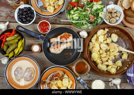 Varie tradizionale American snack con grigliate di cosce di pollo e patate fritte sul tavolo da pranzo Foto Stock