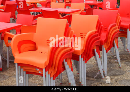 Gruppo di orange sedie vuote di plastica in fila Foto Stock