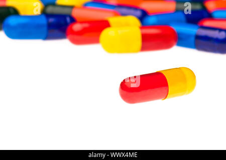 Uno rosso giallo capsula di fronte a molte colorate Foto Stock
