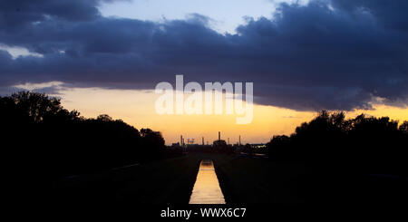 Fiume Emscher con BP raffineria di petrolio al tramonto, Gelsenkirchen, zona della Ruhr, Germania, Europa Foto Stock