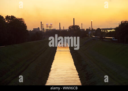 Fiume Emscher con BP raffineria di petrolio al tramonto, Gelsenkirchen, zona della Ruhr, Germania, Europa Foto Stock