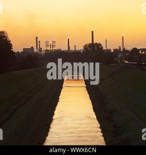 Fiume Emscher con BP raffineria di petrolio al tramonto, Gelsenkirchen, zona della Ruhr, Germania, Europa Foto Stock