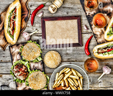 Hot Dog e birra su di un tavolo di legno. In stile rustico, vista dall'alto hamburger fatti in casa a base di carne di manzo Foto Stock