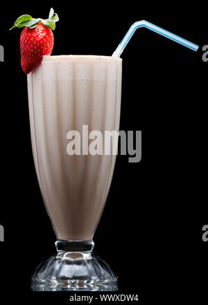 Un delizioso freddo frullato di frutta o latte shake decorato con fragola. Isolato su nero Foto Stock