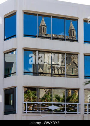 Cattedrale della Santissima Trinità Bermuda, visto distorto e riflessa in un ufficio del blocco di windows Foto Stock