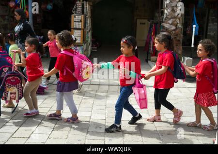 Poco arabo ragazze azienda uno per un altro andando a scuola in Akko, Israele Foto Stock