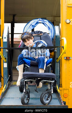 Disabilitato little boy sul bus di scuola di sollevamento per sedia a rotelle Foto Stock