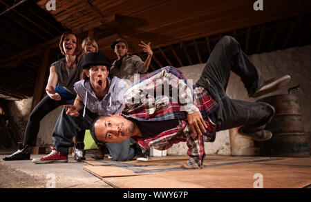 Giovane uomo asiatico esegue break dancing si muove su cartone Foto Stock
