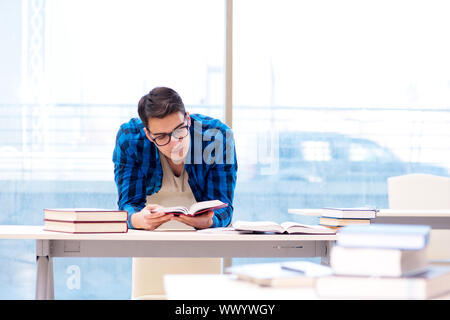 Studente nella libreria vuota con libro preparando per ex Foto Stock