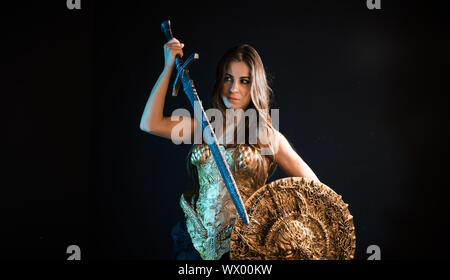 Medievale, valkyrie guerriero, donna con golden armor rivestire di ferro e grande guerriero spada Foto Stock