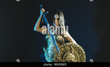 Arma, valkyrie guerriero, donna con golden armor rivestire di ferro e grande guerriero spada Foto Stock