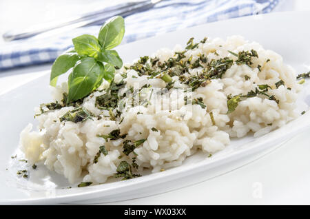 Riso per risotti con fresco tritato erbe del giardino e le foglie di basilico su una piastra Foto Stock